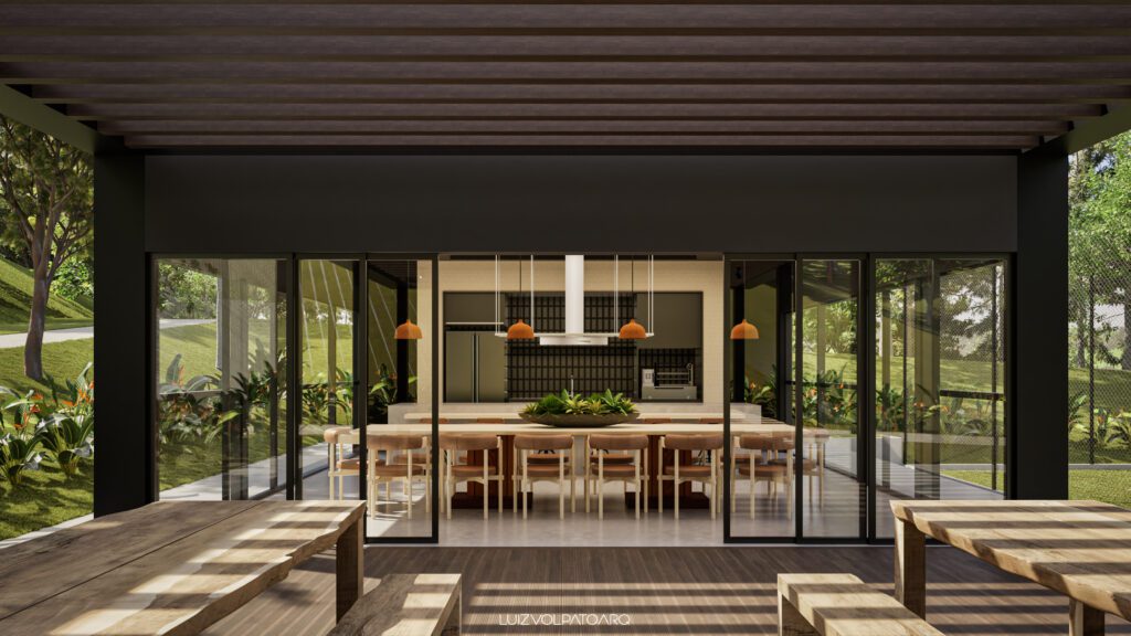 Área de jantar moderna com longas mesas e cadeiras de madeira, paredes de vidro, luminárias pendentes, plantas exuberantes tanto no interior quanto no exterior e uma vista para árvores e vegetação ao fundo. O espaço tem um ambiente elegante, aberto e acolhedor. - Luiz Volpato Arquitetura