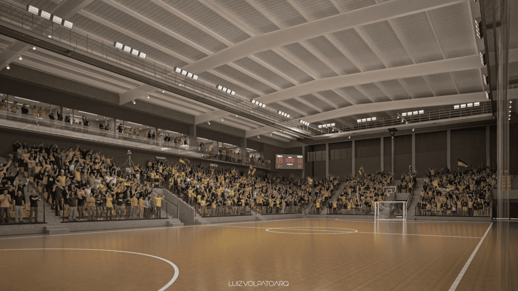 Um grande ginásio esportivo coberto com quadra de madeira, teto alto e muitos torcedores vestidos de amarelo e preto nas arquibancadas. O placar mostra o resultado de 53 a 58. O ambiente é animado e cheio de energia. - Luiz Volpato Arquitetura